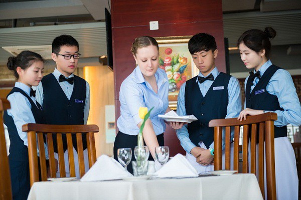 Sinh viên ngành QTNHKS trong giờ thực hành kĩ năng phục vụ bàn tiệc
